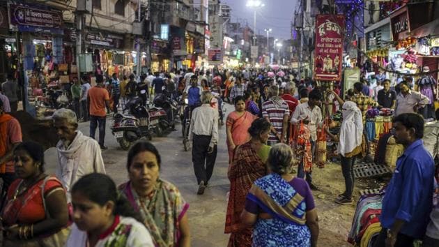 Pedestrians and shoppers walk past stores on a street in Varanasi, Uttar Pradesh. (Bloomberg) Pedestrians and shoppers walk past stores on a street in Varanasi, Uttar Pradesh. (Bloomberg)