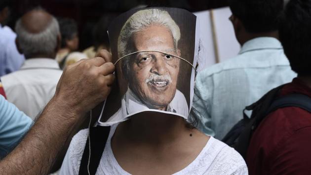 A protester adjusts a portrait of poet Varavara Rao on the face of another protester during a demonstration in New Delhi on August 30, 2018. The Supreme Court (SC) on Wednesday however, stopped Pune police from taking custody of five activists, and placed them under house arrest in their respective homes until the case is heard again on September 6. (Burhaan Kinu / HT Photo)