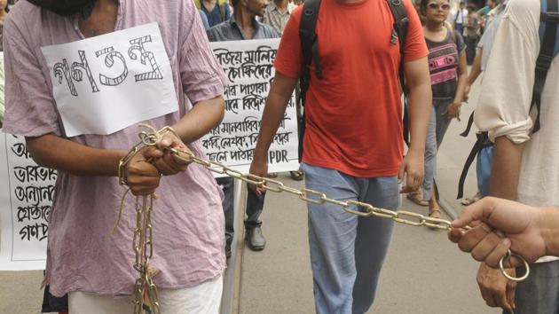 Citizens under Association for Protection of Democratic Rights (APDR) banner walk chained during a protest rally against the arrests, in Kolkata on August 29, 2018. Charged with criminal conspiracy, creating fear and enmity between various groups, and under the Unlawful Activities (Prevention) Act, those arrested on Tuesday were being brought to Pune on transit remand to be produced in the court on Wednesday. (Samir Jana / HT Photo)