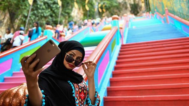 A woman takes selfies in front of the newly-painted 272-steps staircase leading to Malaysia’s Batu Caves Hindu temple in Kuala Lumpur, Malaysia. (Manan Vatsyayana / AFP)
