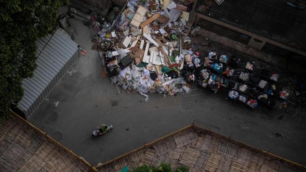 A motorist rides past a trash collection area near a residential high rise building in Shanghai, China. (Johannes Eisele / AFP)
