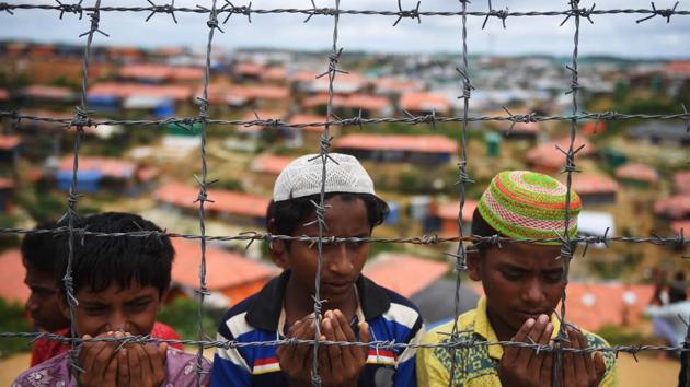 Rohingya refugees perform prayers as they attend a ceremony organised to remember the first anniversary of a military crackdown that prompted a massive exodus of people from Myanmar to Bangladesh, at the Kutupalong refugee camp in Ukhia. (Dibyangshu Sarkar / AFP)
