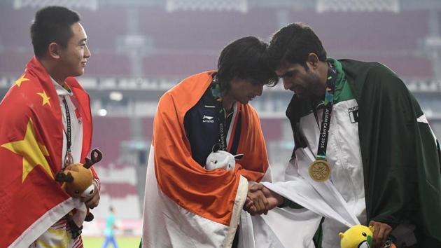 (L-R) Silver medallist China’s Liu Qizhen watches as gold medallist India’s Neeraj Chopra shakes hands with bronze medallist Pakistan’s Arshad Nadeem during the victory ceremony for the men’s javelin throw athletics event during the 2018 Asian Games in Jakarta, Indonesia. (Jewel Samad / AFP) (L-R) Silver medallist China’s Liu Qizhen watches as gold medallist India’s Neeraj Chopra shakes hands with bronze medallist Pakistan’s Arshad Nadeem during the victory ceremony for the men’s javelin throw athletics event during the 2018 Asian Games in Jakarta, Indonesia. (Jewel Samad / AFP)