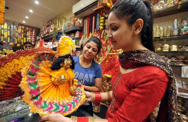 Ladies buying the idols of Lord Krishna ahead of Janmashtami in Jalandhar. (Pardeep Pandit/ht)