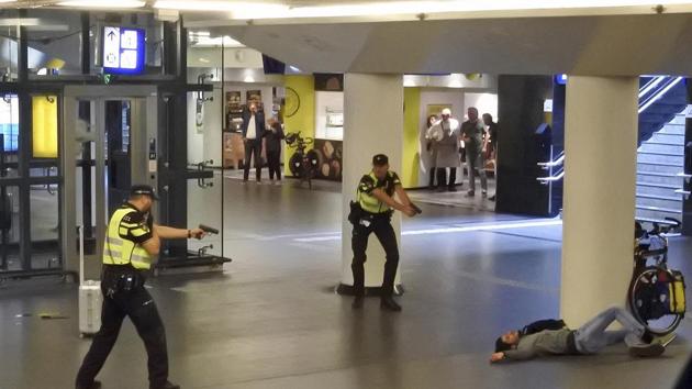 Dutch police officers point their guns at a wounded 19-year-old man who was shot by police after stabbing two people in the central railway station in Amsterdam, the Netherlands, Friday Aug. 31, 2018. (AP) Dutch police officers point their guns at a wounded 19-year-old man who was shot by police after stabbing two people in the central railway station in Amsterdam, the Netherlands, Friday Aug. 31, 2018. (AP)