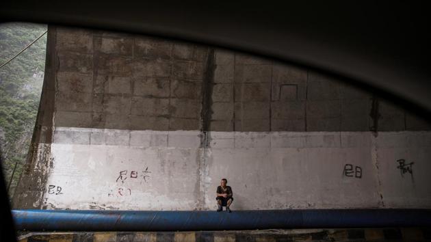 A man finds shelter from the rain inside a tunnel. The dams sat on an unnamed tributary of the flood-prone Dadu river, where the government says “irregular development” of thousands of small hydropower projects has wrecked the ecology. But green groups say the campaign will not necessarily save the environment because it wont affect big state hydropower stations, which they say have caused the most damage. (Damir Sagolj / REUTERS)
