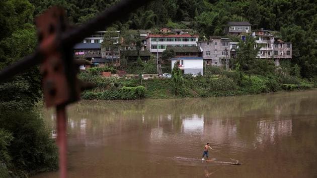 A man manoeuvres a small raft as he goes fishing on the Zhougong. The government says small dams have disrupted the habitats and breeding patterns of many rare species of fish, although green groups argue the damage wrought by bigger dams is more severe, with entire towns and ecosystems submerged in water, which they say increases the risk of earthquakes, landslides and even climate change. (Damir Sagolj / REUTERS)