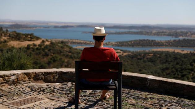 A man waits for sunset at a viewpoint at Alqueva reservoir. But nowhere may escape the impact of global warming for long. Portugal had its own deadly fires last year after a three-year drought, with a big blaze south of Alqueva this year. In a scenario of more frequent and longer droughts, an expanded Alqueva may no longer be sustainable by 2030-2040, requiring tough conservation efforts. (Rafael Marchante / REUTERS) A man waits for sunset at a viewpoint at Alqueva reservoir. But nowhere may escape the impact of global warming for long. Portugal had its own deadly fires last year after a three-year drought, with a big blaze south of Alqueva this year. In a scenario of more frequent and longer droughts, an expanded Alqueva may no longer be sustainable by 2030-2040, requiring tough conservation efforts. (Rafael Marchante / REUTERS)