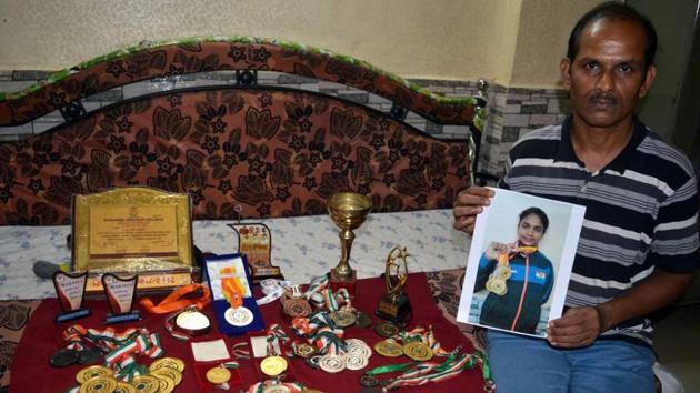 Bhakti Khamkar’s father poses with her medals.(HT Photo) Bhakti Khamkar’s father poses with her medals.(HT Photo)