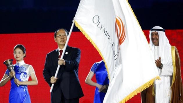China's Olympic Committee chairman Gou Zhongwen, left, waves the Olympic Flag of Asia as Olympic Council of Asia president Sheikh Ahmad al-Fahad al-Sabah, right, watches. (AP)
