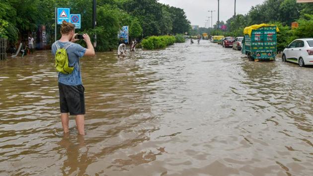 A person takes a photo while standing on a waterlogged street following monsoon rains, in New Delhi on Sunday, Sept 2, 2018.(PTI Photo)