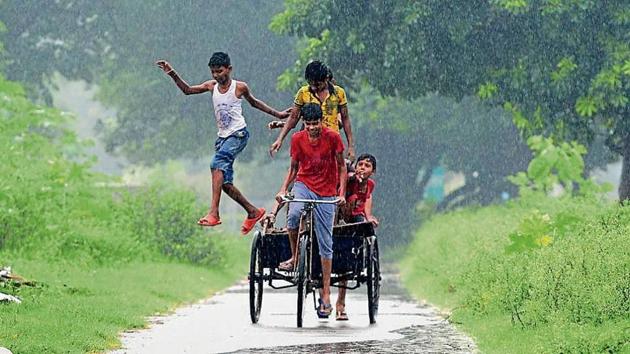 Children in a playful mood during the rain in Chandigarh on Sunday. At 27.9°C, maximum temperature fell by four notches as compared to that on Saturday.(HT Photo)