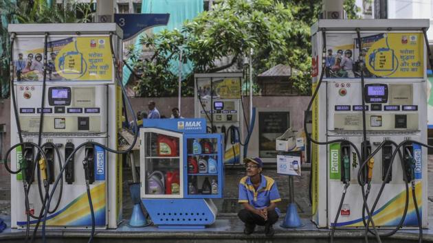 An attendant sits between two fuel pumps at a gas station in Mumbai.(Bloomberg) An attendant sits between two fuel pumps at a gas station in Mumbai.(Bloomberg)