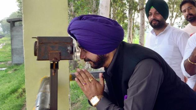 Cricketer-turned-minister Navjot Singh Sidhu pays obeisance, viewing Gurdwara Kartarpur Sahib, located in Pakistan, through binoculars from the Indo-Pak border. Sidhu, attacked by critics for his visit to Pakistan for Imran Khan’s oath ceremony and a hug shared with the Pakistani army chief, said his belief that India-Pakistan ties were set to improve has strengthened after his return, as his “friend” Imran Khan has sent a message that he wants peace. (PTI File) Cricketer-turned-minister Navjot Singh Sidhu pays obeisance, viewing Gurdwara Kartarpur Sahib, located in Pakistan, through binoculars from the Indo-Pak border. Sidhu, attacked by critics for his visit to Pakistan for Imran Khan’s oath ceremony and a hug shared with the Pakistani army chief, said his belief that India-Pakistan ties were set to improve has strengthened after his return, as his “friend” Imran Khan has sent a message that he wants peace. (PTI File)