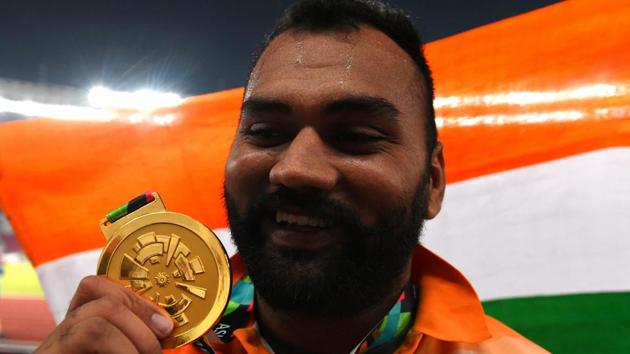 India's Tajinderpal Singh Toor celebrates after receiving his gold medal for the men's shot put during the athletics competition.(PTI)