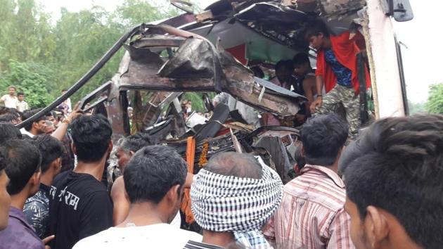 Crowds gather to see the remains of the buses involved in an accident near Aligarh on Tuesday.(HT PHOTO)