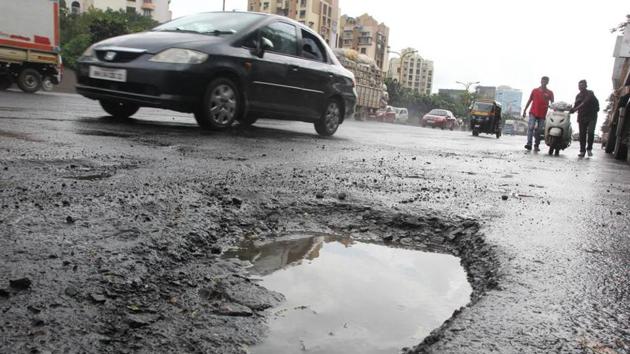 Potholes on the eastern express highway road near Jupiter Hospital continue to be a source of trouble for commuters.(HT Photo)