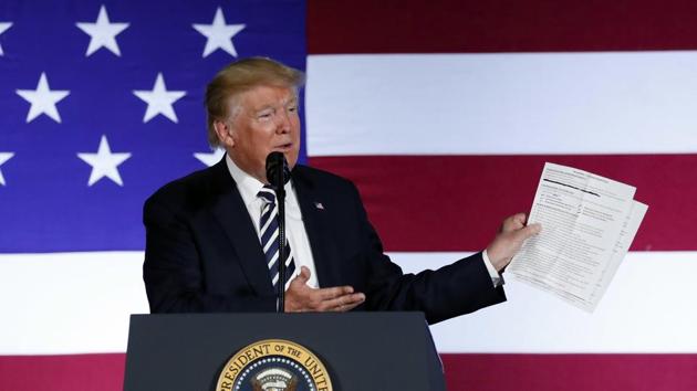 In this Aug. 31, 2018, photo, President Donald Trump holds up a list of his administrations accomplishments while speaking at a Republican fundraiser at the Carmel Country Club in in Charlotte, N.C.(AP File Photo)