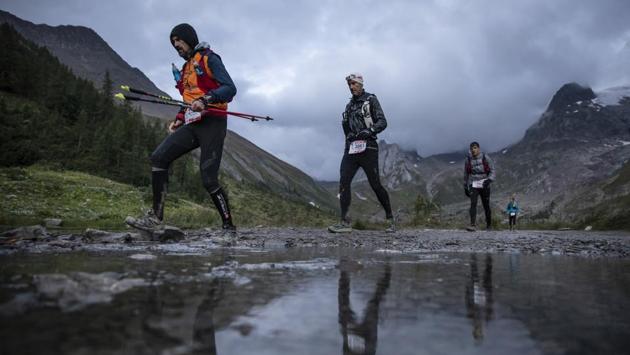 Competitors run next to the Combal lake as they compete in the UTMB race, in Courmayeur, Italy. The race has strict entry and qualification requirements, racers accumulating enough race points through qualifying trail races over the previous two-year period. (Laurent Cipriani / AP) Competitors run next to the Combal lake as they compete in the UTMB race, in Courmayeur, Italy. The race has strict entry and qualification requirements, racers accumulating enough race points through qualifying trail races over the previous two-year period. (Laurent Cipriani / AP)