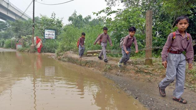 Students on their way to school near Yamuna bank on a rainy day. Hundreds of informal schools are running across the Capital, but there is no official data on their tally. Sanjay Goel, director at the Delhi government’s Directorate of Education said that they have relaxed many admission norms to help students studying in these schools enter formal education and are giving admission to classes based on their age. (Sushil Kumar / HT Photo) Students on their way to school near Yamuna bank on a rainy day. Hundreds of informal schools are running across the Capital, but there is no official data on their tally. Sanjay Goel, director at the Delhi government’s Directorate of Education said that they have relaxed many admission norms to help students studying in these schools enter formal education and are giving admission to classes based on their age. (Sushil Kumar / HT Photo)