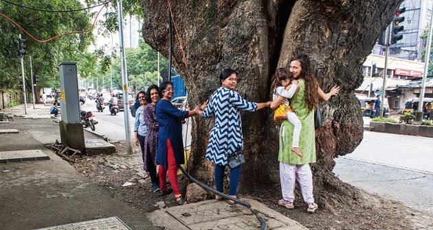 Residents form a human chain to save a tree along LBS Road on Thursday.(Satish Bate/HT Photo)