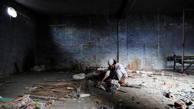 A scrap dealer searches for useful material at a weaving factory that was shut a year ago, in Panipat, Haryana. India launched the Goods and Services Tax (GST) just over a year ago, its biggest ever tax reform, aiming to replace more than a dozen federal and state levies and unify the sprawling economy. (Adnan Abidi / REUTERS)