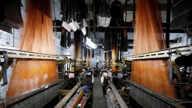 A labourer works on a powerloom. To address grievances, the GST Council, which administers the measure, has approved more than 200 amendments since the law came into force. The Federation of Indian Export Organisations estimates that nearly $2 billion of tax credits were yet to be refunded mainly because of software glitches and difficulties in matching hundreds of thousands invoices. (Adnan Abidi / REUTERS)
