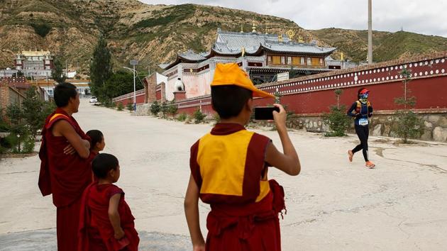 Tibetan Buddhist monks wave to a participant. The race, in its first official year, brought in just over 500 runners, filling the town’s lone hotel, with some guests staying for a few days after the event. Ying’s company provided salmon for the athletes to eat, prize money of up to 15,000 yuan, and presented the male 100km winner with his body weight in salmon. (Thomas Peter / REUTERS) Tibetan Buddhist monks wave to a participant. The race, in its first official year, brought in just over 500 runners, filling the town’s lone hotel, with some guests staying for a few days after the event. Ying’s company provided salmon for the athletes to eat, prize money of up to 15,000 yuan, and presented the male 100km winner with his body weight in salmon. (Thomas Peter / REUTERS)