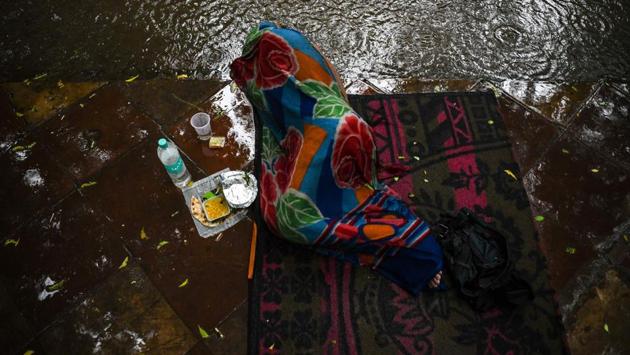 A homeless man sleeps on a footpath during heavy rainfall in New Delhi. (Chandan Khanna / AFP) A homeless man sleeps on a footpath during heavy rainfall in New Delhi. (Chandan Khanna / AFP)