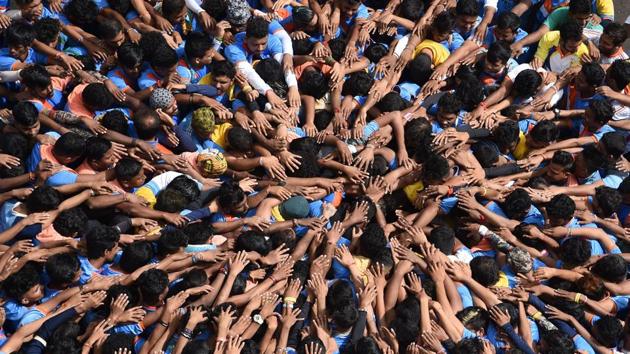 Hindu devotees take a vow before forming a human pyramid in a bid to reach and break a ‘dahi handi’ suspended in the air during celebrations for Janmashtami in Mumbai, Maharashtra. (Indranil Mukherjee / AFP) Hindu devotees take a vow before forming a human pyramid in a bid to reach and break a ‘dahi handi’ suspended in the air during celebrations for Janmashtami in Mumbai, Maharashtra. (Indranil Mukherjee / AFP)
