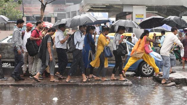 Commuters shelter under umbrellas as they walk through a water logged street during rain at Kashmiri gate in New Delhi. (Raj K Raj/HT PHOTO) Commuters shelter under umbrellas as they walk through a water logged street during rain at Kashmiri gate in New Delhi. (Raj K Raj/HT PHOTO)