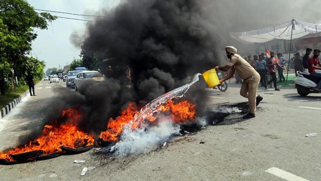 A policeman tries to douse a burning tyres during 'Bharat Bandh' protest called by Congress and other parties against fuel price hike and depreciation of the rupee, in Jammu on September 10. (PTI Photo) A policeman tries to douse a burning tyres during 'Bharat Bandh' protest called by Congress and other parties against fuel price hike and depreciation of the rupee, in Jammu on September 10. (PTI Photo)