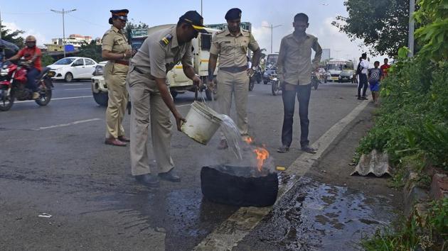A policeman puts out a burning tyre that was set on fire by protesters during the Bharat bandh , in Mumbai on September 10, 2018. (Vijayanand Gupta/HT Photo) A policeman puts out a burning tyre that was set on fire by protesters during the Bharat bandh , in Mumbai on September 10, 2018. (Vijayanand Gupta/HT Photo)