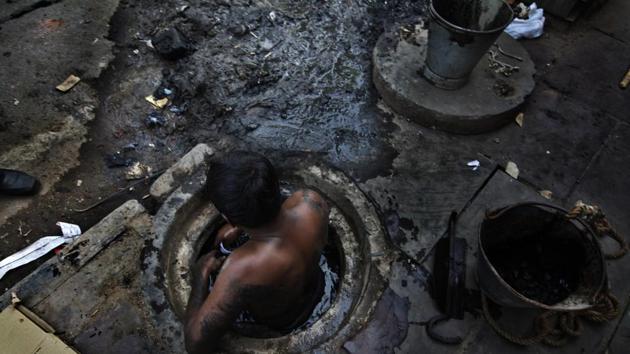 Municipal worker attempts to unblock a sewer, New Delhi, October 7, 2009(Raj K Raj / Hindustan Times)