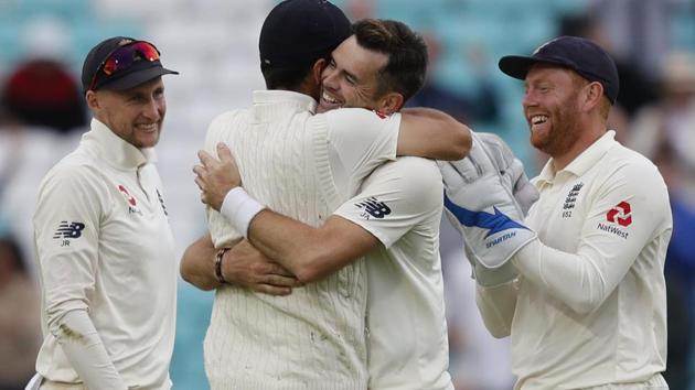 England's James Anderson (C) celebrates with England's Alastair Cook after taking the wicket of India's Mohammed Shami. (AFP) 