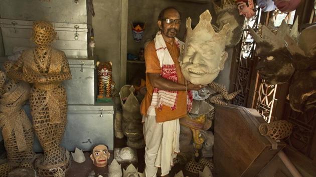 Traditional mask maker Hemachandra Goswami holds up a mask at Samaguri Satra. “Our Maha (great) guru Srimanta Sankardeva had established this art in the 15-16th centuries. He started with painting stories and that gave birth to Bhaona. The masks are essential for Bhaonas,” said 60-year old Goswami. (Anupam Nath / AP)
