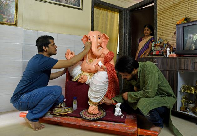 A resident of Shanti Nagar gives finishing touches to an idol of shadu clay, at Mira Road on Tuesday.(Satyabrata Tripathy/HT Photo)