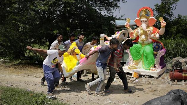 People carry an idol of Ganesha at a workshop in New Delhi, ahead of the ‘Ganesh Chaturthi’ festival that celebrates the birth of the elephant headed god. (Altaf Qadri / AP) People carry an idol of Ganesha at a workshop in New Delhi, ahead of the ‘Ganesh Chaturthi’ festival that celebrates the birth of the elephant headed god. (Altaf Qadri / AP)