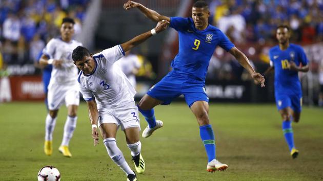 El Salvador defender Roberto Dominguez (left) chases after the ball alongside Brazil forward Richarlison. (AP) El Salvador defender Roberto Dominguez (left) chases after the ball alongside Brazil forward Richarlison. (AP)