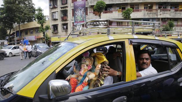 A devotee transports an idol of the elephant-headed God in a taxi in Mumbai. With massive crowds expected to participate in the celebrations, security arrangements across the city see an increase in CCTV cameras, use of drones and deployment of anti-terror squads and bomb squads. (Rafiq Maqbool / AP) A devotee transports an idol of the elephant-headed God in a taxi in Mumbai. With massive crowds expected to participate in the celebrations, security arrangements across the city see an increase in CCTV cameras, use of drones and deployment of anti-terror squads and bomb squads. (Rafiq Maqbool / AP)