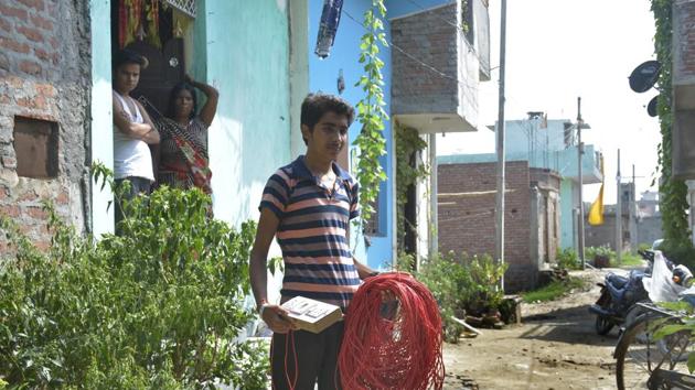 A Kanawani resident holds a roll of wire and a switchboard. They use this to draw electricity from another locality so that they can run submersibles and fill up water tanks for their daily needs. (Sakib Ali/ HT Photo) A Kanawani resident holds a roll of wire and a switchboard. They use this to draw electricity from another locality so that they can run submersibles and fill up water tanks for their daily needs. (Sakib Ali/ HT Photo)