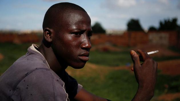 Arouna Diabate, 19, smokes as he sits at the donkey pasture. Diabate receives a monthly salary of around $35 at his trash collection job. “I won’t be picking up trash with a donkey cart for the rest of my life, but for now people appreciate us because we help clean up the homes of Bamako,” he said. (Luc Gnago / REUTERS) 