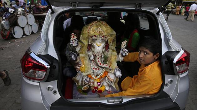 A boy sits with an idol of Ganesha in the trunk of a car in Mumbai. This year, the festival is being held from September 13 to September 23. (Rafiq Maqbool / AP) A boy sits with an idol of Ganesha in the trunk of a car in Mumbai. This year, the festival is being held from September 13 to September 23. (Rafiq Maqbool / AP)