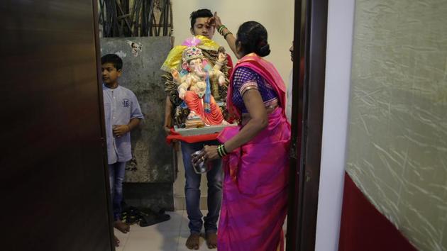 Devotees offer prayers before entering their homes with an idol during Ganesh Chaturthi festival celebrations in Mumbai. (Rafiq Maqbool / AP) Devotees offer prayers before entering their homes with an idol during Ganesh Chaturthi festival celebrations in Mumbai. (Rafiq Maqbool / AP)