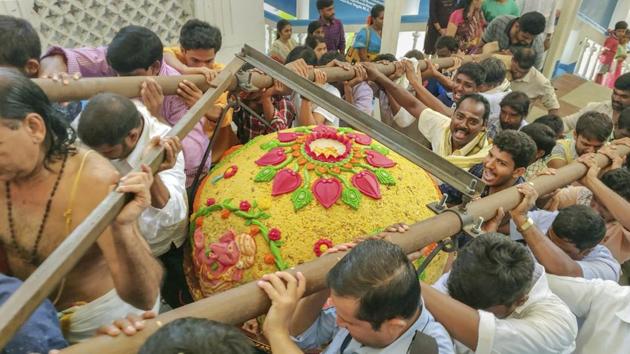 Devotees carry a laddu, weighing about 580 kgs, to offer to Lord Ganesh at Film Nagar Daiva Sannidhanam on the occasion of Ganesh Chaturthi in Hyderabad on September 13.(PTI Photo)