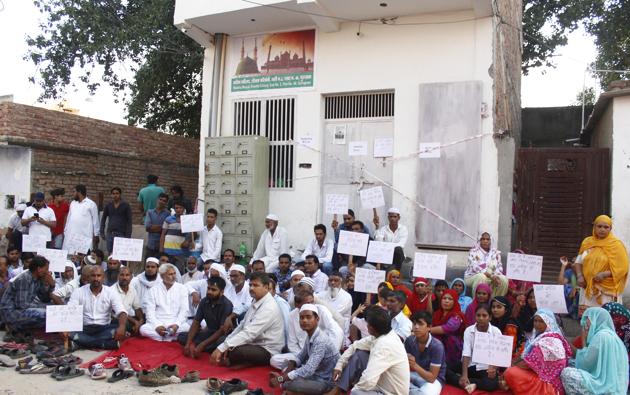 Muslim Ekta Manch leaders, along with other members from the Muslim community, on Thursday, continued their dharna outside the mosque in Sheetla Mata Colony that was sealed by officials of the Municipal Corporation of Gurugram (MCG) on Wednesday.(Yogendra Kumar/HT Photo)