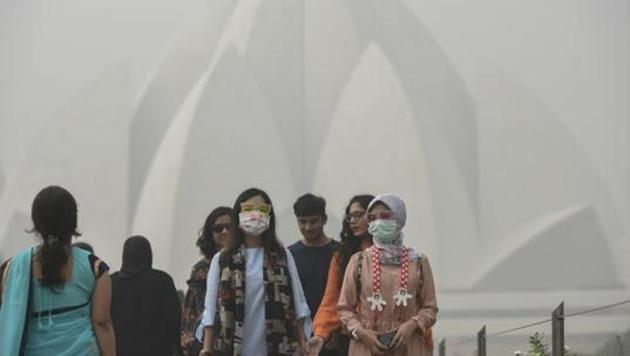 Foreign tourists wearing masks as they visit Lotus Temple on a smoggy morning, in New Delhi, India.(HT File Photo)