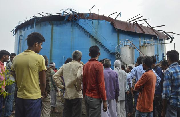 People stand near the site of explosion at a petro-chemical factory, where a methane gas boiler tank blasted killing six workers, in Bijnor on September 12.(PTI Photo)