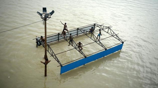 Children play atop submerged restroom at Daraganj Ghat as they bathe on the flooded banks of the Ganga river in Allahabad, Uttar Pradesh on September 11, 2018. (Sanjay Kanojia / AFP) 