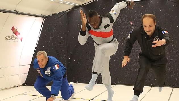 Jamaican retired sprinter Usain Bolt (C), French Interior designer Octave de Gaulle (R) and French former astronaut Jean-François Clervoy (L) in zero-gravity conditions in an aircraft above Reims during a promotional event for the Mumm Grand Cordon Stellar champagne designed to be drank by space tourists. (Laurent Theillet / Mumm / Novespace /AFP)